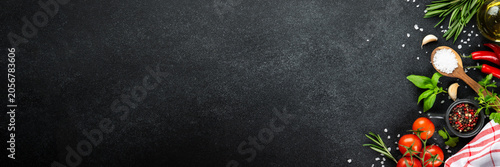 Healthy food background. Fresh tomatoes, basil, rosemary on black table. Web banner format.