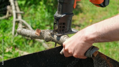 A close-up of cutting a branch with a jigsaw