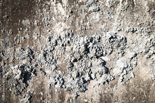 Grunge grey concrete wall texture with rough cement plaster splatters.
