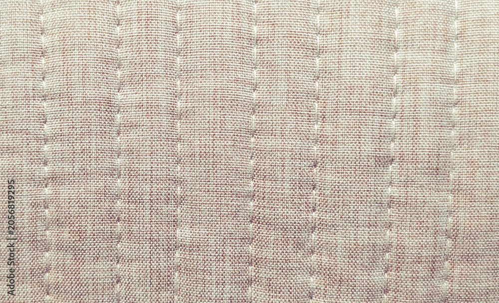 Fototapeta premium close up of beige melange quilted fabric with vertical stitching