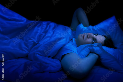 Bilde på lerret Stressed man lying awake in bed at night suffering from insomnia