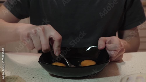 Vivid kitchen food preparation. Closeup of eggs being scrambled during cooking. Detailed scene of culinary task in warm cooking space. Vivid depiction of eggs being mixed in cozy kitchen setting