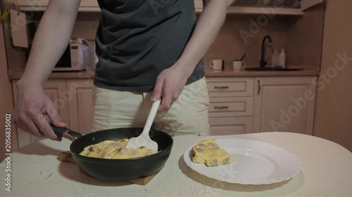 Teen expertly places fluffy eggs. Individual enjoys quick morning meal by placing golden omelette in kitchen