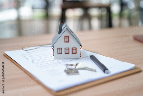 Photos Real Estate Concept with House Model and Keys on Property Documents