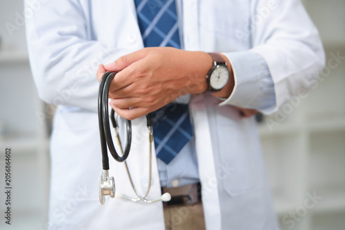 Medical professional holding a stethoscope in a clinical setting