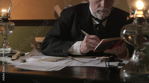 Naval architect writing in a notebook with a dip pen