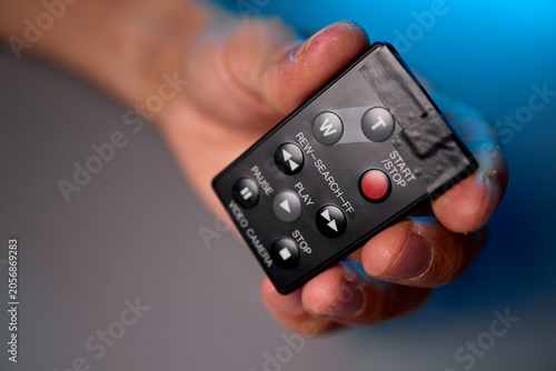 Obraz na płótnie Close-up of hands adjusting a small black remote control