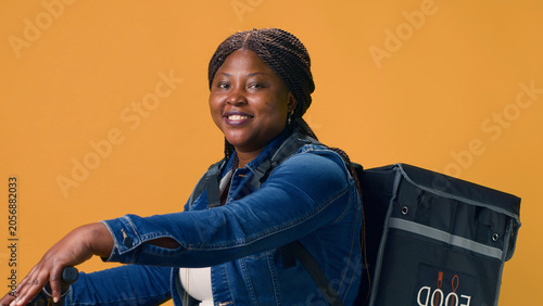 Obraz na płótnie Youthful female courier riding modern bicycle for delivering packages with efficiency through city streets, with woman with food delivery bag actively working on-demand
