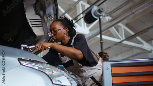 Photography Licensed repairman in repair shop using torque wrench to tighten screws after checking car parameters during maintenance, expert using professional tool in garage to mend vehicle, close up shot