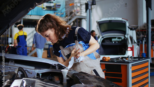 Bilde på lerret Mechanic in repair shop using torque wrench to tighten screws after opening car to check its parameters during maintenance, specialist using professional tool in garage to recondition busted vehicle