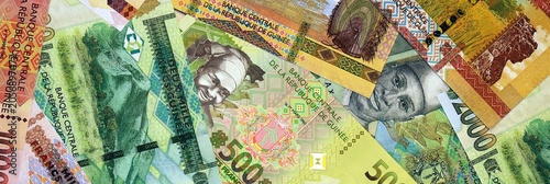Photos Guinean franc money bills in pile on table