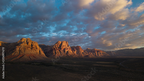 Fotografie Beautiful aerial drone photograph of Red Rock Canyon outside Las Vegas with puffy clouds in the sky at sunrise