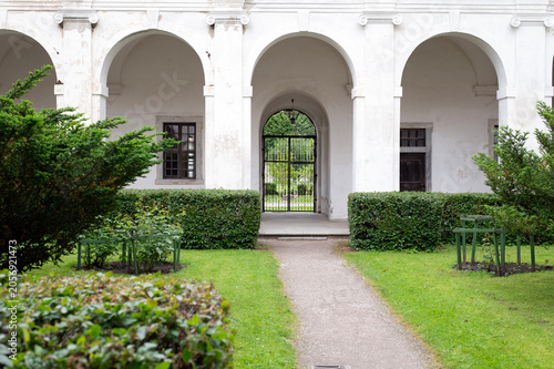 Historic Courtyard Garden With Arched Walkway and Wrought-Iron Gate in Classical Building