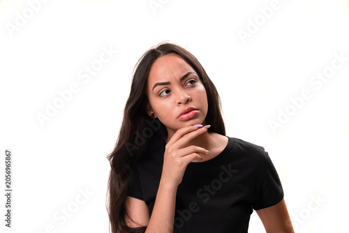 Pensive young latina woman looking away and thinking isolated on white background.