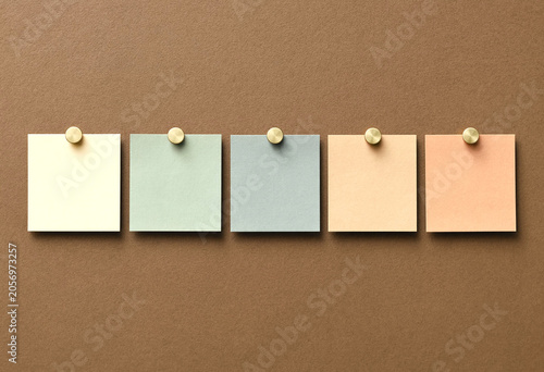 Empty pastel sticky notes pinned on corkboard minimalist flat lay composition