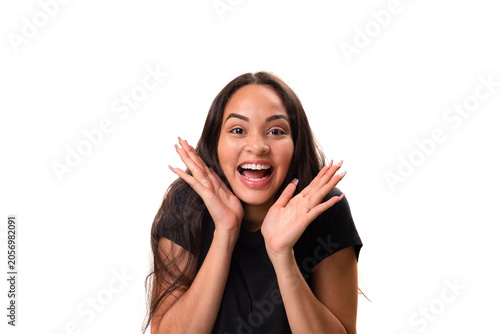 Overjoyed young latina woman laughing with hands near face isolated on white background.