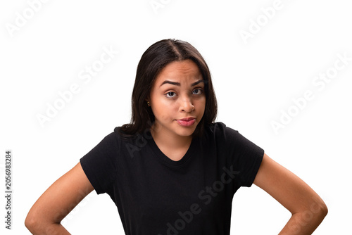 Skeptical young latina woman standing with hands on hips isolated on white background.