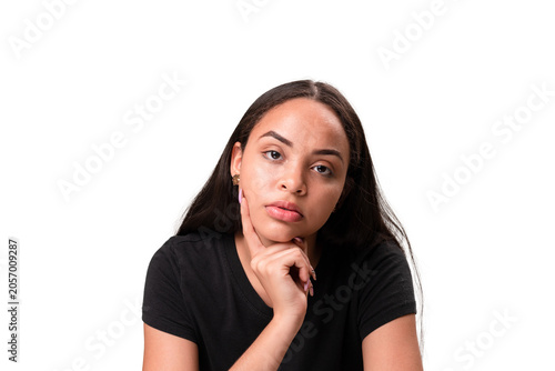 Bored young latina woman resting chin on hand isolated on white background.
