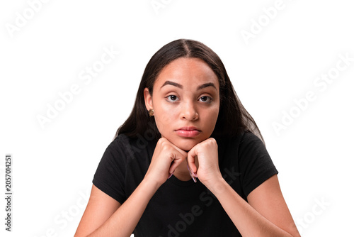 Bored young latina woman resting chin on fists isolated on white background.