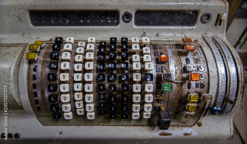 Close-up of Vintage Mechanical Accounting Machine Keyboard. An antique mechanical accounting machine, with worn white and black numeric keys, rusted metal texture, and banking transaction buttons.