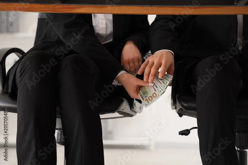 Fotografija Business people exchanging money under table, bribery and corruption in corporat