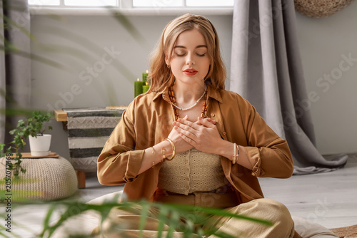Beautiful young woman meditating at home. Zen concept
