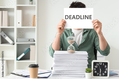 Man holding deadline sign w...