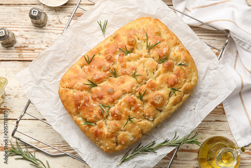 Obraz na plátne Freshly baked focaccia bread with rosemary and sea salt on cooling rack, rustic
