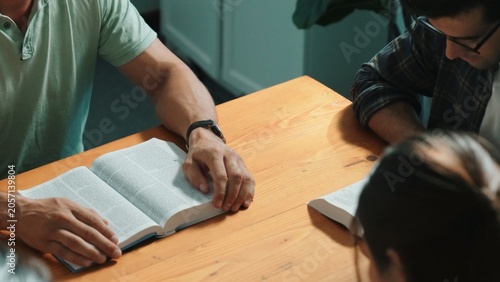Fotografija Top view of christian prayer holding each other support while reading bible books cross with faith, spirituality and religion