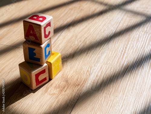 Wooden alphabet blocks stack on floor