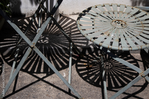The midday sun makes the shadows of the outdoor iron table vivid.한낮의 태양이 야외철제 테이블의 그림자를 선명하게 만듭니다.