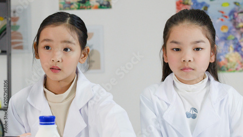 Photography Two Young Thai Girls in Lab Coats Observing a Science Experiment