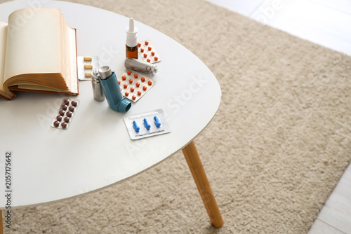 Tableau sur toile Modern inhaler, pills and asthma aerosol canisters on coffee table in living roo