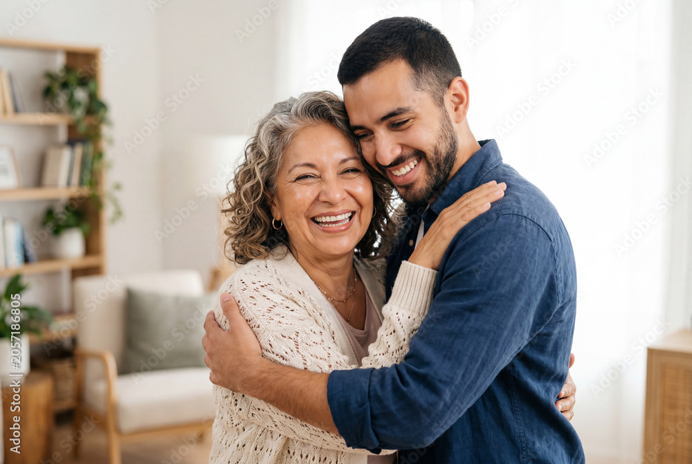 Fototapeta premium Smiling senior woman embracing a young man in a living room