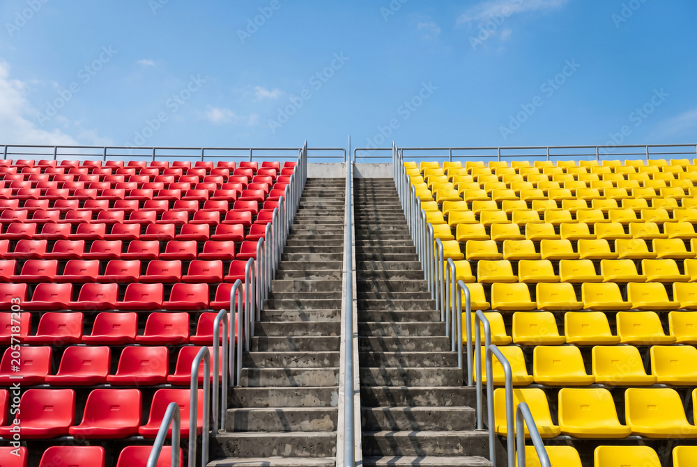 Fototapeta premium Empty stadium seating providing red and yellow plastic rows