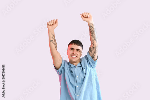 Excited young man with tatt...