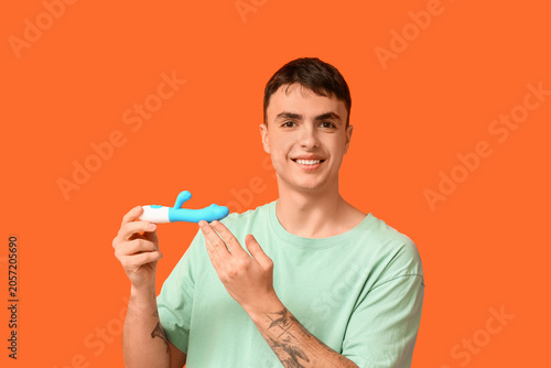 Smiling young man holding b...