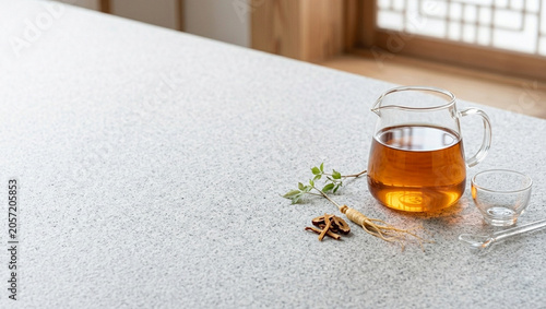 Warm hot tea pouring into a glass cup on a stone counter