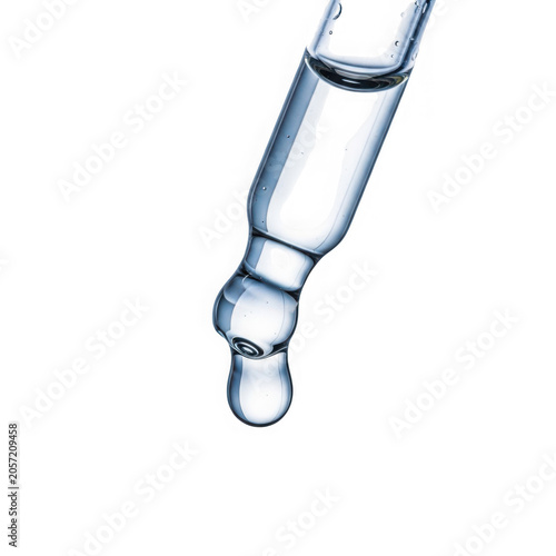 Close up of a clear liquid droplet falling from a glass dropper.