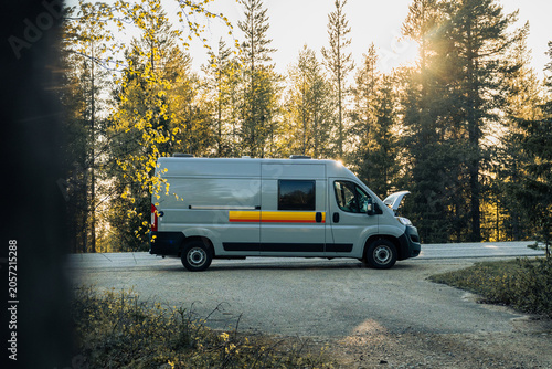Foto camper van parked on forest road during golden hour in finland