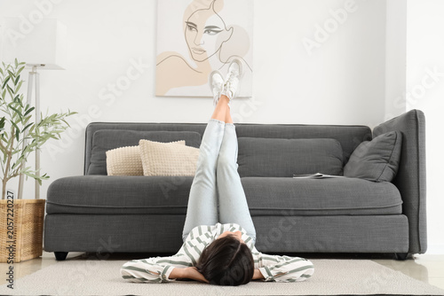 Young woman lying on floor ...