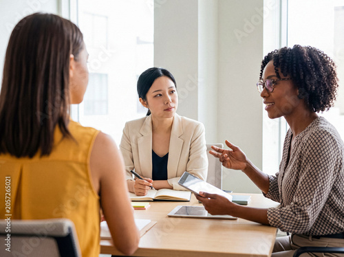 Quadro su tela Photograph of diverse businesswomen collaborating during a meeting in a modern office environment