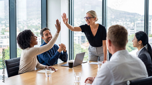 Valokuva Energetic multiethnic business team celebrating a successful project with high fives in a bright office