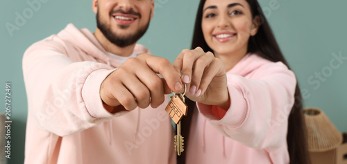 Happy young couple with key...