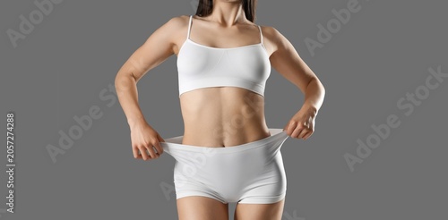 Картината върху платно Slim female body in white underwear showing weight loss and healthy lifestyle on