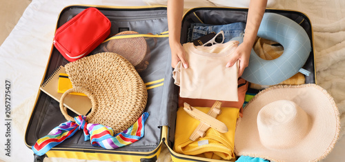 Young woman packing clothes...
