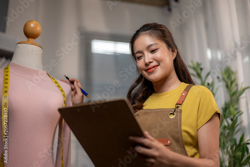 Fashion designer woman creating new clothing measuring mannequin
