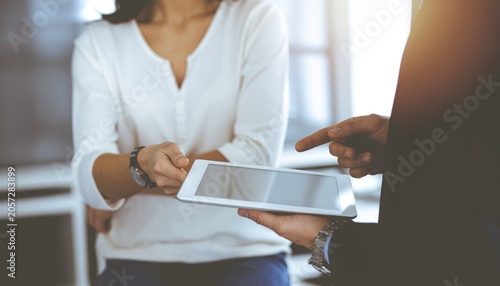 Creative team collaborating around digital tablet, innovation and teamwork concept