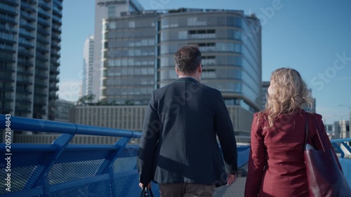Business colleagues talking outside modern office building.