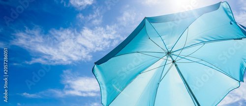 Fotografía Bright blue beach umbrella providing summer sun protection against a clear sky w